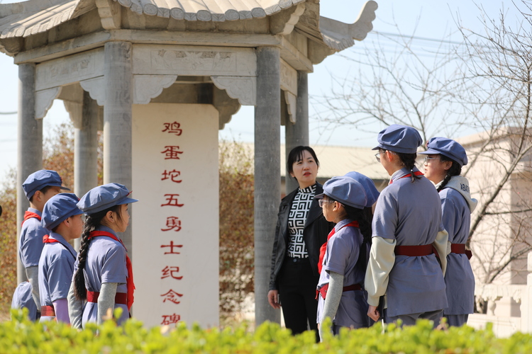 河北涞水：手绘风筝寄哀思 绿色清明祭英烈_fororder_图为工作人员向学生讲述革命先烈的英勇事迹。（徐梓钰 摄）.JPG