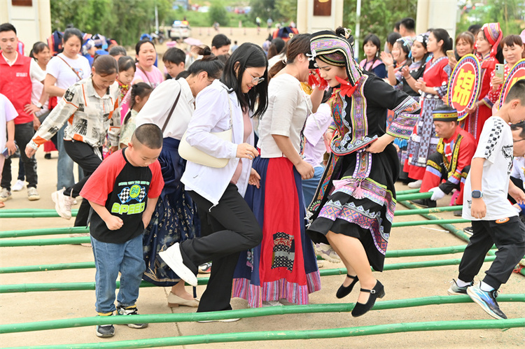 【潮起三月三】广西象州：妙皇三月三茶旅文化活动点“燃”乡村旅游新爆点_fororder_游客在体验跳竹竿舞.JPG