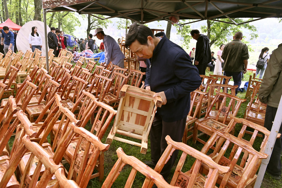 信阳新县：“非遗大市集”火热开市_fororder_游客正在挑选凳子（焦汉平 摄）