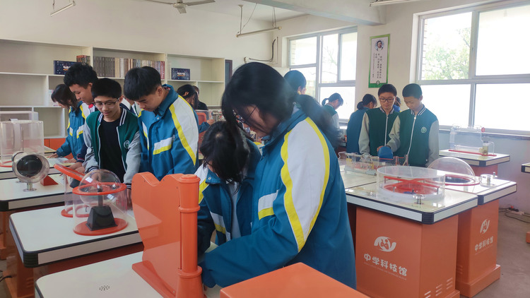 河北唐县：农村科技馆点燃学生“科技梦”_fororder_学生们正对20个展台和展板逐一参观