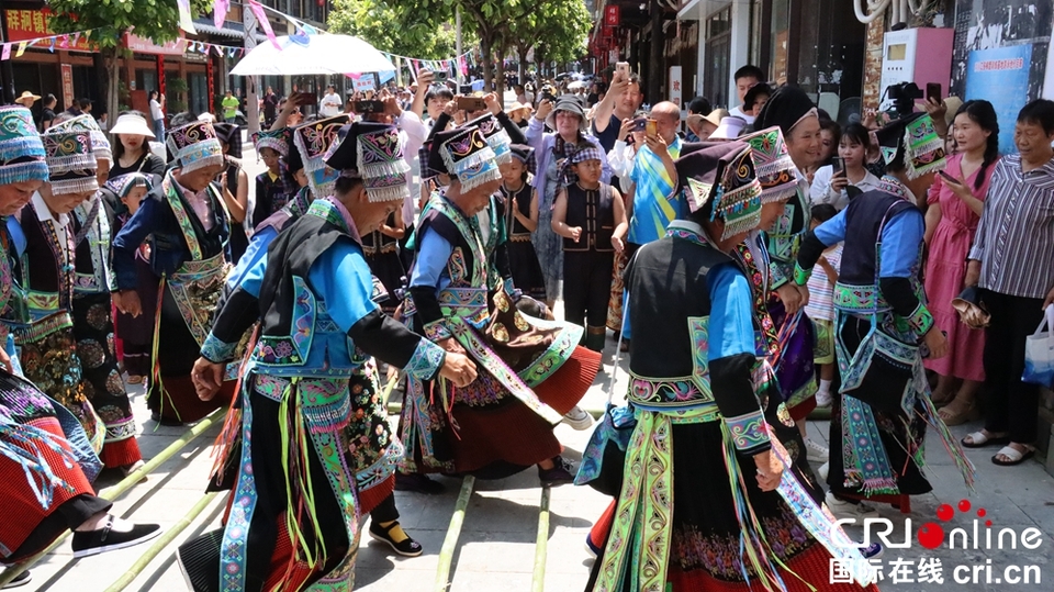 月亮河“六月六”布依风情节盛大开启 点燃现场激情_fororder_7月10日，牂牁镇“六月六”民族团结大联欢活动布依族同胞跳竹竿舞.JPG