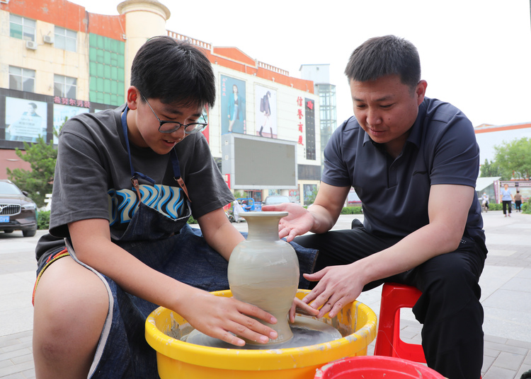 河北涞水：传承非遗技艺 促进文化振兴_fororder_图为非遗传承人正在指导群众体验绞胎瓷制作。（李金璐 摄）.JPG