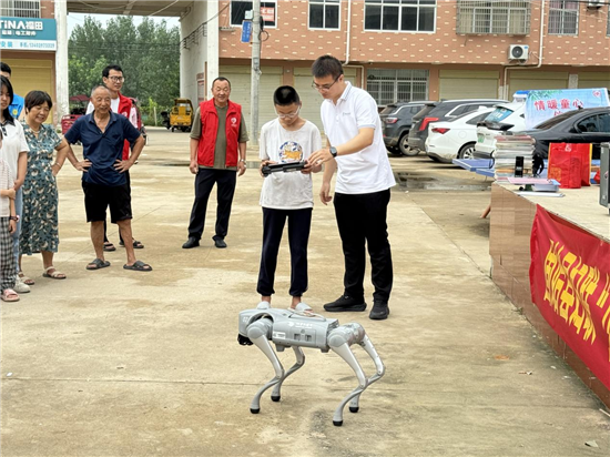 信阳市固始县：科普活动进社区 科学理想启少年_fororder_科学老师指导孩子操作机器狗