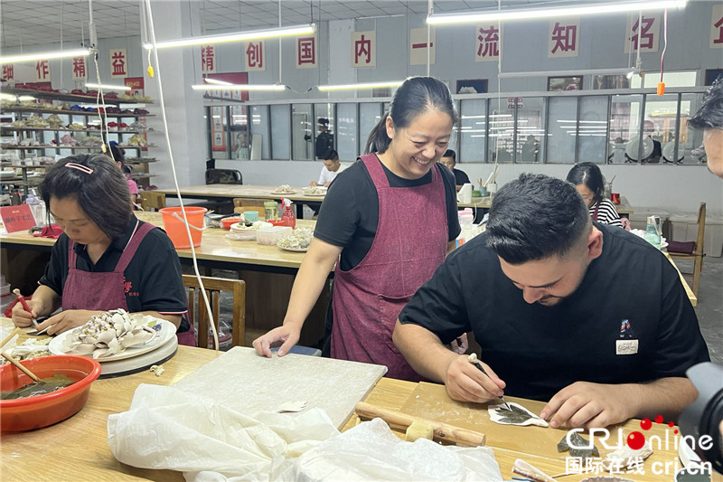 【何以中国 行走河南】在洛阳牡丹瓷博物馆 开启“国瓷国花”探秘之旅_fororder_外国朋友体验牡丹瓷花叶制作