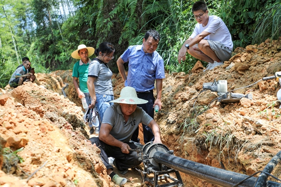 贵州天柱：探索建立湘黔两省联合帮扶工作机制_fororder_驻村干部查看消防水池建设进度.JPG