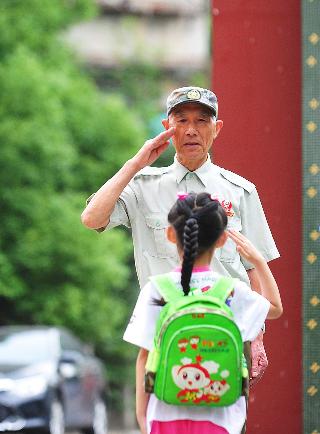 幼儿园前的敬礼爷爷 18年坚持给孩子问好