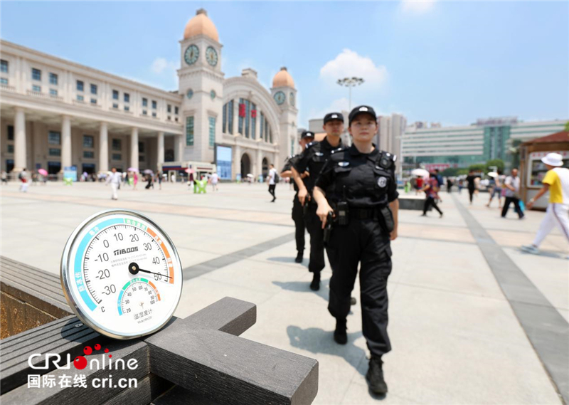 武汉48℃高温 女特警挂枪值守火车站