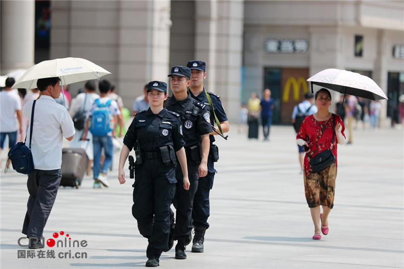 武汉48℃高温 女特警挂枪值守火车站