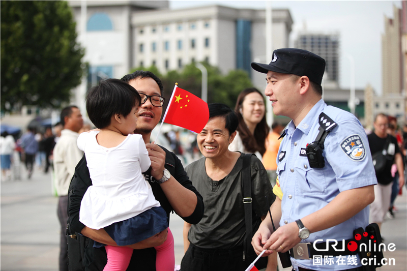 火车站里国旗飘扬 警民共庆国庆