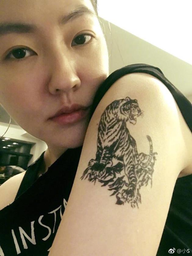 "照片中,小s一脸素颜,表情高冷,手臂上露出老虎图案的纹身特写,看上去