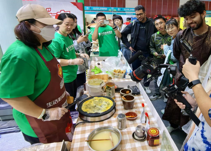 Visite de l'Exposition du marathon de Tianjin : Les jeunes internationaux découvrent la culture gastronomique typique de Tianjin