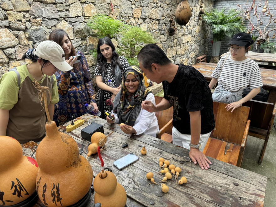 Foreign Guests Marvel at Gourd Carving Technique in Licheng District, Jinan